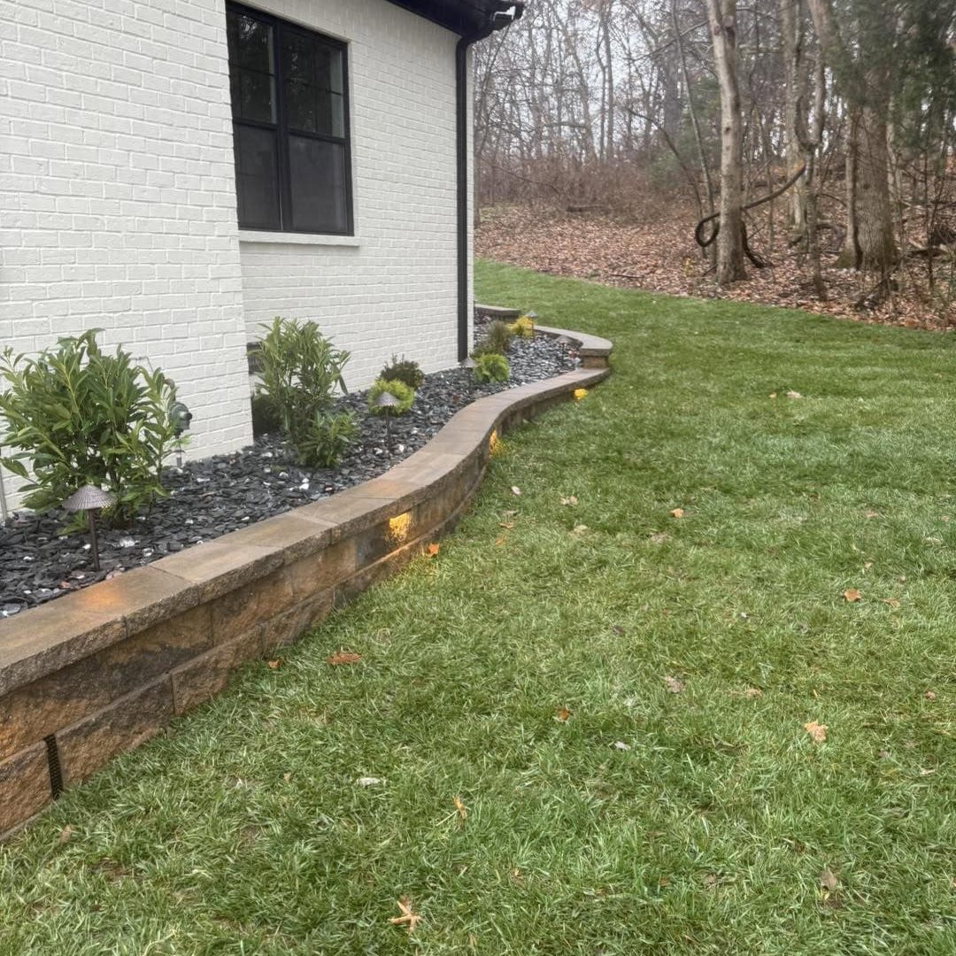 Beautiful backyard landscape featuring a garden bed with shrubs and a well-maintained lawn.