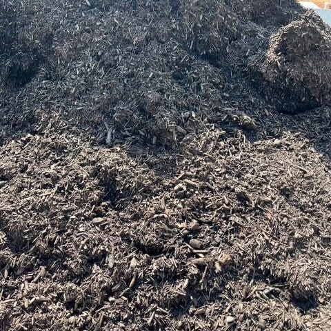 Dark organic mulch for garden beds and landscaping projects.